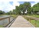 Scenic wooden bridge with a calming lake view and beautiful greenery around the community at 1625 Oak Leaf St, Daniel Island, SC 29492
