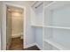 Walk-in closet leading to a bathroom, featuring built-in shelving and wooden rod, and ample storage space at 1625 Oak Leaf St, Daniel Island, SC 29492