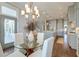 Light-filled dining area with a glass table and a modern chandelier, flowing into the kitchen at 1625 Oak Leaf St, Daniel Island, SC 29492