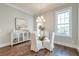 Bright dining room featuring a modern chandelier, a round glass-top table and an elegant sideboard at 1625 Oak Leaf St, Daniel Island, SC 29492