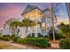 Charming two-story home with double porches, palm trees, manicured landscaping, and inviting curb appeal at 1625 Oak Leaf St, Daniel Island, SC 29492