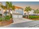 Home exterior featuring a two-car garage and palm trees at sunset at 1625 Oak Leaf St, Daniel Island, SC 29492