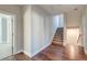 Well-lit hallway with hardwood floors leading to a carpeted staircase at 1625 Oak Leaf St, Daniel Island, SC 29492