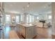 Open-concept kitchen featuring a large center island with marble countertops, stainless steel appliances, and hardwood floors at 1625 Oak Leaf St, Daniel Island, SC 29492
