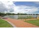 Scenic view of the lake, lush landscaping, and a brick walking path at Smythe Lake at 1625 Oak Leaf St, Daniel Island, SC 29492