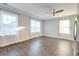 Bright living room featuring hardwood floors, white curtains, and multiple windows for natural light at 1625 Oak Leaf St, Daniel Island, SC 29492