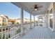 Covered porch with white columns, wooden floors, ceiling fan, and community views at 1625 Oak Leaf St, Daniel Island, SC 29492