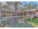 Rustic chicken coop featuring wood construction, wire mesh, and metal roof amidst a natural wooded setting at 1677 French Santee Rd, Jamestown, SC 29453