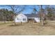 Charming home exterior with a wooden porch, surrounded by a spacious lawn and mature trees at 1677 French Santee Rd, Jamestown, SC 29453