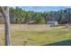 View of the outbuildings, barn, and sheds around the property with surrounding green fields and a tree line at 1677 French Santee Rd, Jamestown, SC 29453