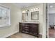 Bathroom with a double sink vanity, granite counters, wood cabinets, and decorative mirrors at 1723 River Front Dr, Charleston, SC 29407