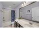 Well-lit bathroom featuring a large mirror, white vanity, and shower with a blue patterned curtain at 1782 Towne St, Johns Island, SC 29455