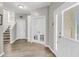 Bright foyer with hardwood floors, showcasing a staircase, coat closet, and glass panel doors for a grand entrance at 1782 Towne St, Johns Island, SC 29455