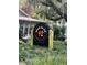 Outdoor signage for Wild Olive Cucina Italiana with statues flanking the circular sign in a natural setting at 1782 Towne St, Johns Island, SC 29455