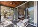 Relaxing covered balcony with comfortable seating that opens up to the bright and stylish living room at 1981 Central Park Rd, Charleston, SC 29412