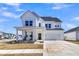 Charming two-story home with white siding, a covered front porch, and a two-car garage at 201 Garden Lily Lane, Summerville, SC 29485