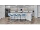 Modern kitchen with gray cabinets, quartz countertops, stainless steel appliances, and an island with seating at 201 Garden Lily Lane, Summerville, SC 29485