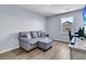 Living room with a gray sofa, ottoman, a window, and a TV setup at 201 Garden Lily Lane, Summerville, SC 29485