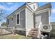 Gray home featuring an entrance door with stairs, gray siding, and white trim at 2097 Mt Pleasant St, Charleston, SC 29403