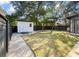 Spacious backyard with a white shed, well-maintained lawn, decorative gravel path, and privacy fencing at 2115 Wappoo Dr, Charleston, SC 29412