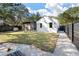 Landscaped backyard featuring a well-maintained lawn, modern fencing, and a cozy screened-in porch for outdoor relaxation at 2115 Wappoo Dr, Charleston, SC 29412