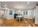 Sunlit dining room boasting hardwood floors, a stylish chandelier, and soft, sheer window curtains at 2115 Wappoo Dr, Charleston, SC 29412