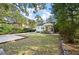 A well-manicured lawn and landscaped garden complement the home's exterior, framed by mature trees at 2115 Wappoo Dr, Charleston, SC 29412