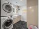 Well-organized laundry room featuring a stacked washer and dryer, modern sink and ample counter space at 2115 Wappoo Dr, Charleston, SC 29412
