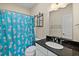 Cozy bathroom with black marble countertop, white cabinets, and a shower with a fun pineapple shower curtain at 3003 Yachtsman Dr, Mount Pleasant, SC 29466