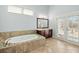 Bright bathroom features a soaking tub with decorative surround and doors to the outdoor porch at 3003 Yachtsman Dr, Mount Pleasant, SC 29466