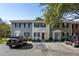 A cozy two-story townhome showcasing a red door, black shutters, and parking spaces in front of the unit at 303 Lakeside Dr # C-2, Mount Pleasant, SC 29464