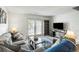 Bright living room with french doors leading to a balcony and gray sectional sofa with patterned pillows at 303 Lakeside Dr # C-2, Mount Pleasant, SC 29464