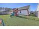 Large backyard features a colorful playset with swings and slide, set against the backdrop of a well-maintained lawn at 311 Citation Way, Moncks Corner, SC 29461