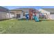 Well-maintained backyard showcasing a vibrant playset with slide and swing alongside a lush lawn and privacy fencing at 311 Citation Way, Moncks Corner, SC 29461