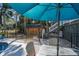 View of fenced backyard with pool, shed, table with umbrella, and tropical trees at 3323 Myrtle St, Edisto Island, SC 29438