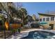 View of backyard pool, shed, outdoor furniture, green home exterior, and tropical trees at 3323 Myrtle St, Edisto Island, SC 29438