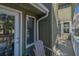 View of home's side with porch, chair, greenery, and sliding glass doors at 3323 Myrtle St, Edisto Island, SC 29438