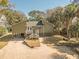 Charming coastal home featuring a welcoming front porch and stilt foundation and lush landscaping at 3323 Myrtle St, Edisto Island, SC 29438