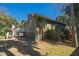 View of backyard with stone walkway, green home exterior, porch, and tropical trees at 3323 Myrtle St, Edisto Island, SC 29438