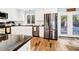 Well lit kitchen with white cabinetry, stainless steel appliances and hardwood floors at 3323 Myrtle St, Edisto Island, SC 29438