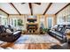 Cozy living room with wood paneling, exposed ceiling beams, a fireplace, and comfortable seating at 3323 Myrtle St, Edisto Island, SC 29438