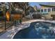 Outdoor pool and patio area with an umbrella, furniture, a storage shed, and a black metal fence at 3323 Myrtle St, Edisto Island, SC 29438