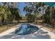 View of fenced backyard pool with surrounding trees, plants, and clear blue sky at 3323 Myrtle St, Edisto Island, SC 29438