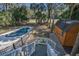 Aerial view of pool and wooden shed, surrounded by lush greenery and a fenced yard at 3323 Myrtle St, Edisto Island, SC 29438