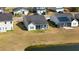 Aerial view of community homes with gray roofs, green lawns, and a pond at 3707 Blackjack Rd, Ladson, SC 29456