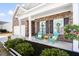 Inviting front porch featuring colorful Adirondack chairs, lush plants, and charming decor at 3707 Blackjack Rd, Ladson, SC 29456
