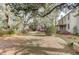 Beautiful landscaped yard with mature trees, blooming azaleas, and a charming two-story home at 408 N Parler Ave, Saint George, SC 29477