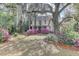 Charming two-story home featuring beautiful landscaping and mature trees draped with Spanish moss at 408 N Parler Ave, Saint George, SC 29477