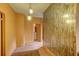 Hallway with patterned wallpaper, vintage light fixtures, and hardwood floors, providing a glimpse into the home's layout at 408 N Parler Ave, Saint George, SC 29477