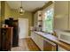 Galley kitchen with stainless steel appliances, light-colored cabinets, and a view of the backyard at 408 N Parler Ave, Saint George, SC 29477